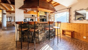 A rustic interior with a stone bar and wooden furniture.