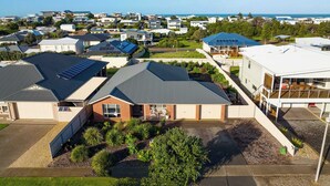 A residential area with houses featuring solar panels, a garage, and a well-maintained lawn. - 15 Offshore Dr Middleton - Wi-Fi and Linen Included (Middleton)