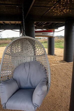 A hanging chair under a structure with a view of the countryside. - Jack & Rose Treehouse Titanic Hot tub Riverfront. (Sevierville)