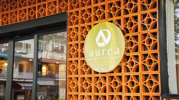 A hotel sign with a geometric pattern and the name 'Aurea Hotels' on a yellow background.