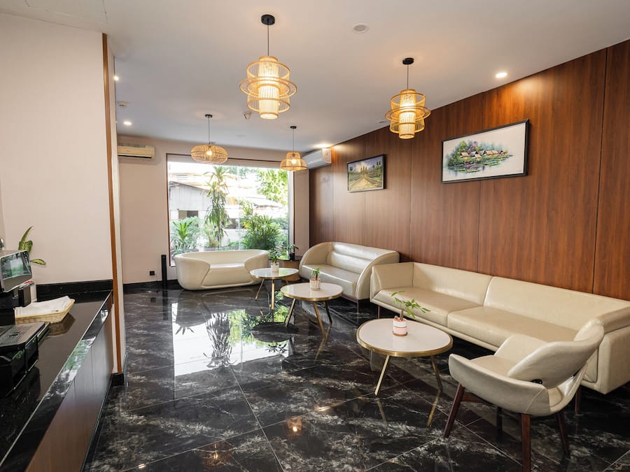 A modern lobby with a sofa, coffee table, and pendant lights.