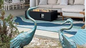 A modern living room with a sofa, a coffee table, and decorative lighting. - Coastal Bummz | Pets | Walk to Beach & Pool (Orange Beach)