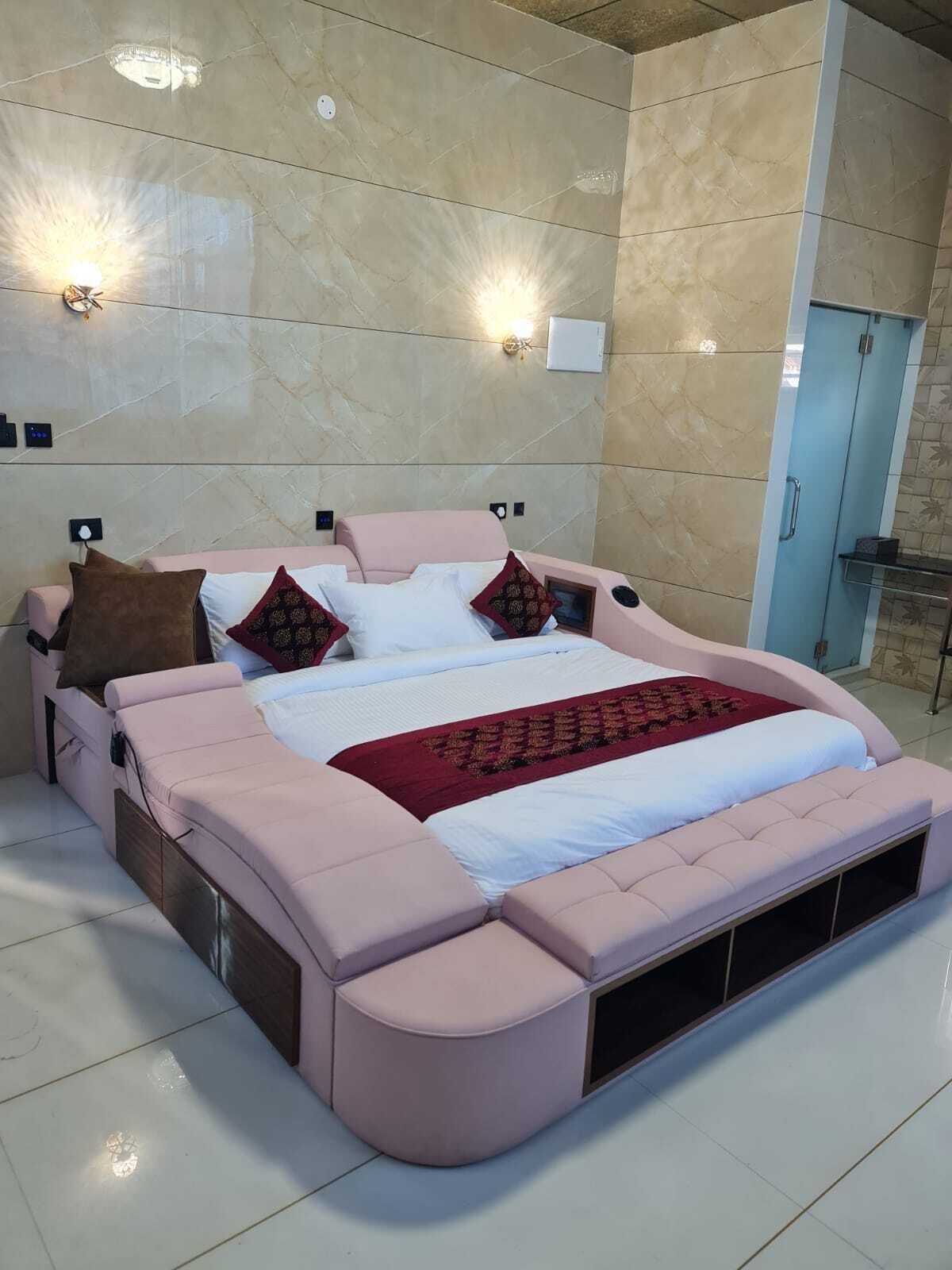 Une chambre moderne avec un grand lit, une table de chevet et un banc intégré.