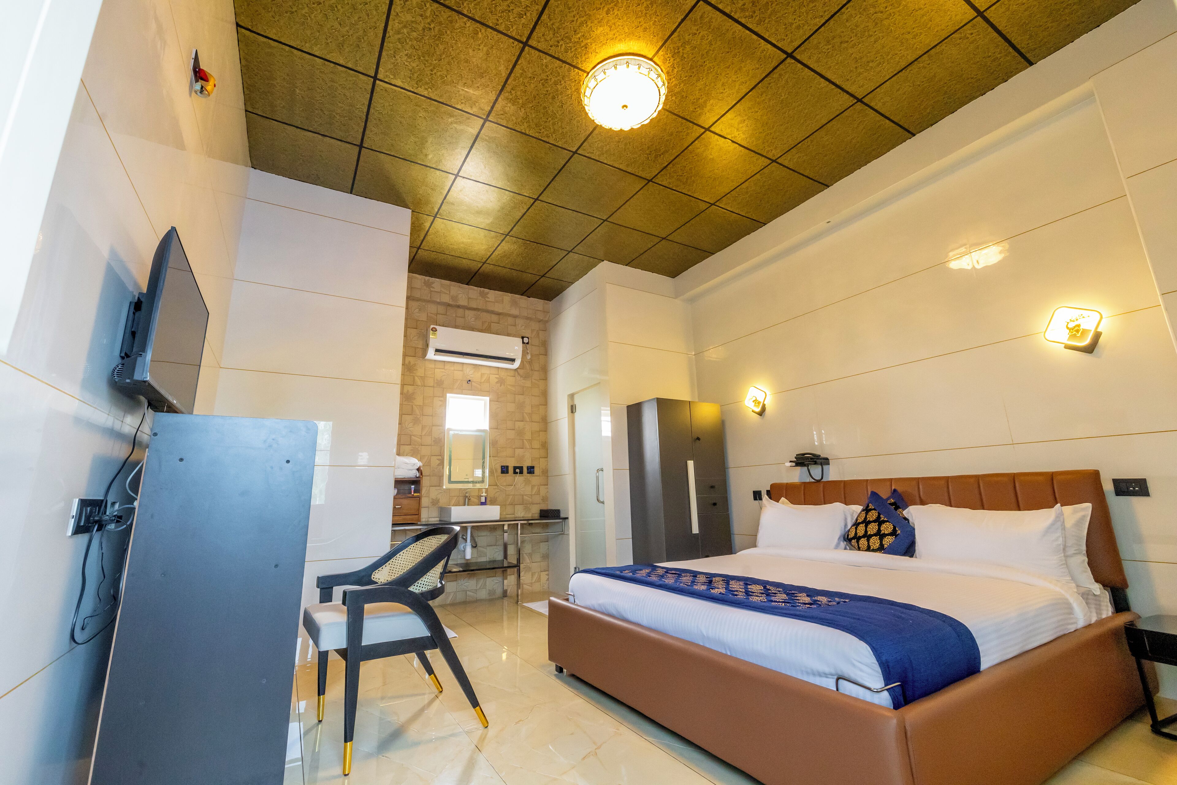 A hotel room with a bed, a desk, and a chair.