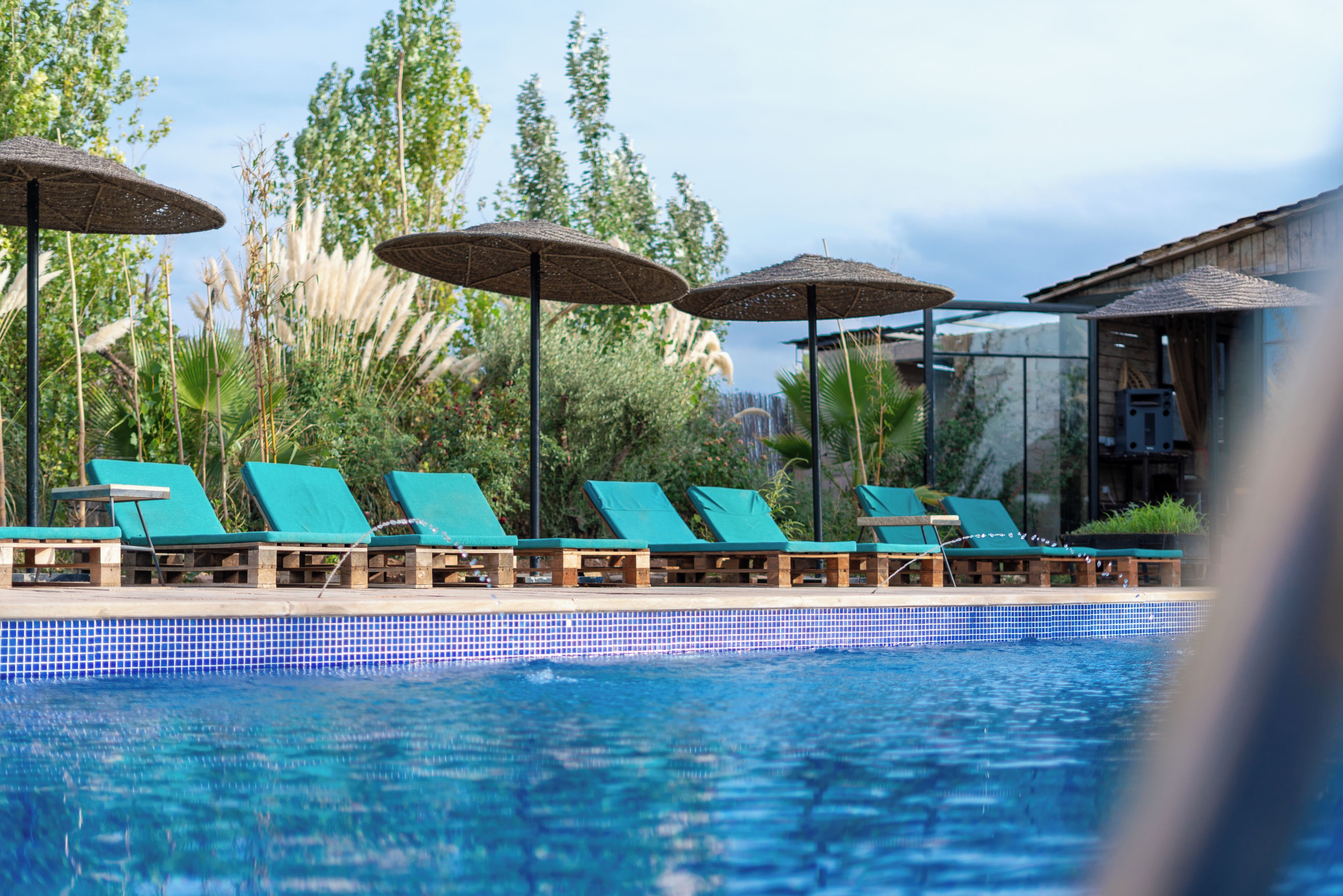 A pool area with lounge chairs and umbrellas.