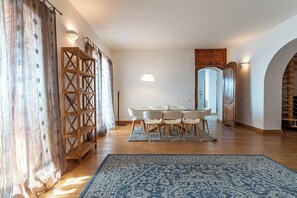 Ruokailutila, jossa on pyöreä pöytä, kuusi tuolia ja sinikuvioinen matto.