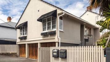 A two-story house with a garage, a picket fence, and mailboxes.