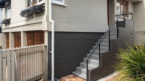 A two-story house with a staircase leading to the upper floor. - 2-bed apartment in the heart of Ponsonby (Auckland)