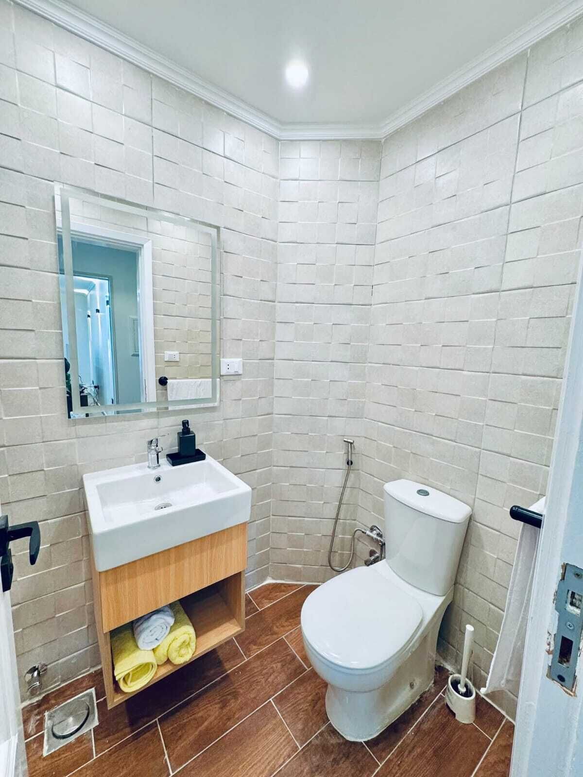 Un baño con lavamanos, inodoro y ducha blancos.