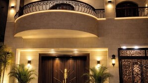 A multi-story building with a grand entrance, a curved balcony, and a decorative metal railing. - Sol Pyramid Inn (Giza)