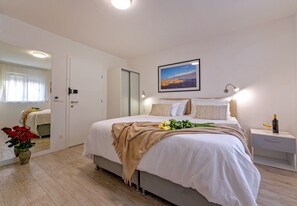 A neatly arranged bedroom with a bed, bedside table, and a nightstand. - Villa Zvonko (Split)