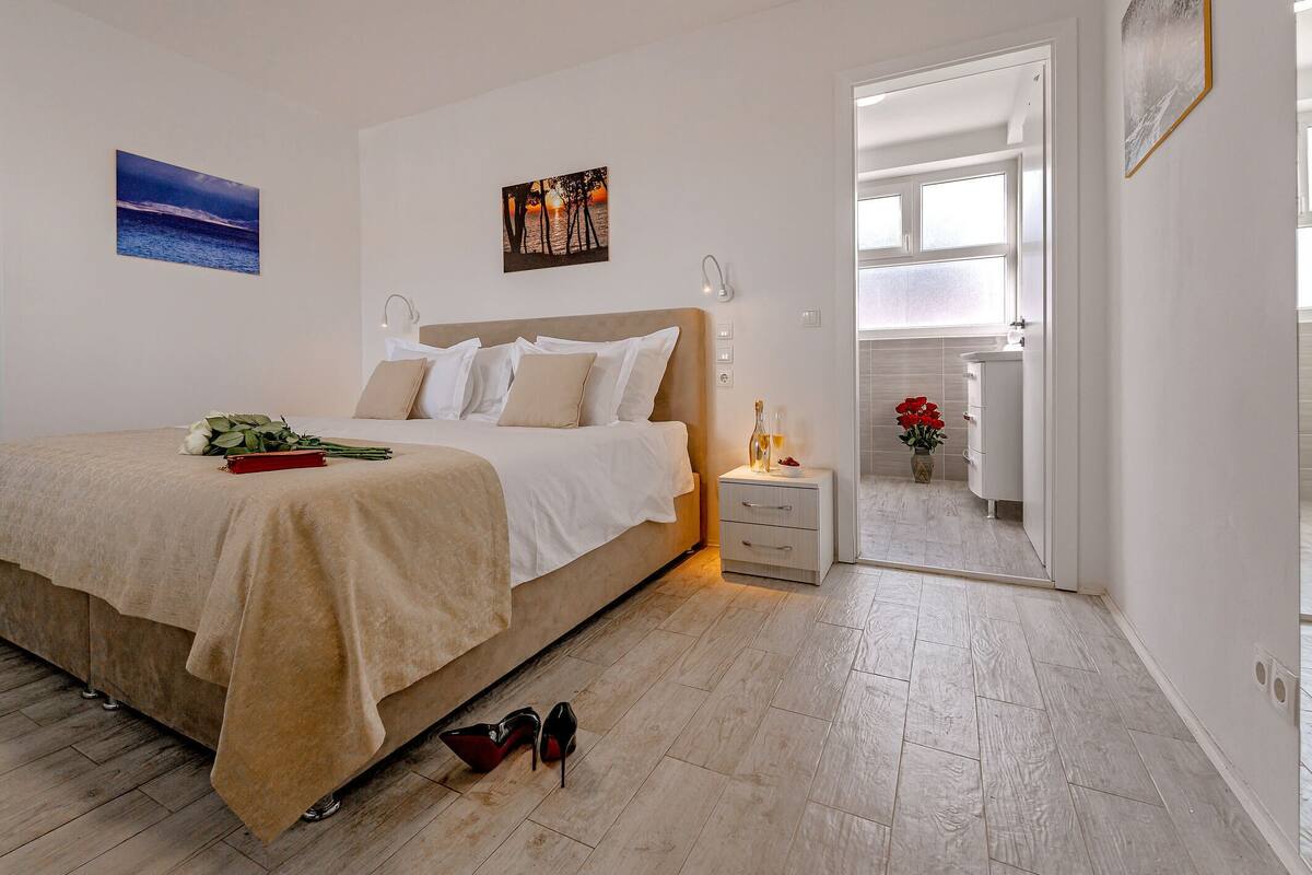 A bedroom with a bed, bedside table, and a nightstand.