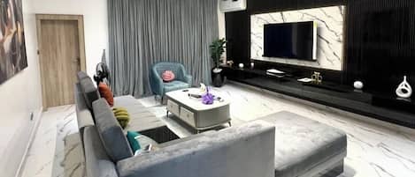 Departamento económico, balcón, vista a la ciudad | Área de sala de estar | Televisión de pantalla plana
