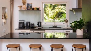 Una cocina moderna con un amplio ventanal, una cafetera y una planta.