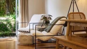Un rincón acogedor con un sillón mullido, una mesita pequeña y una lámpara de pie.