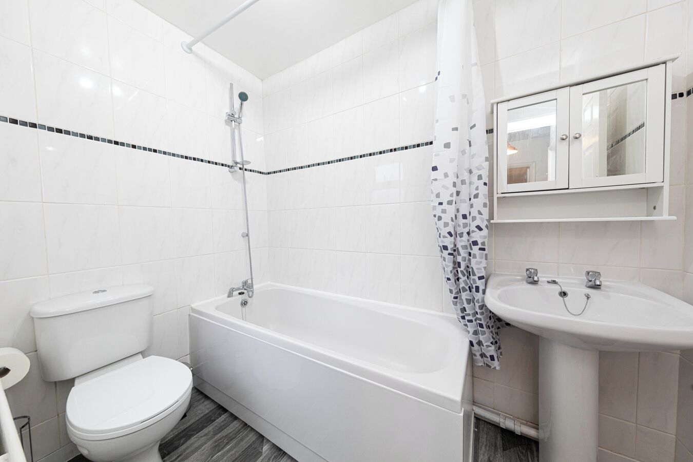Ein modernes Badezimmer mit Toilette, Badewanne und Waschbecken.
