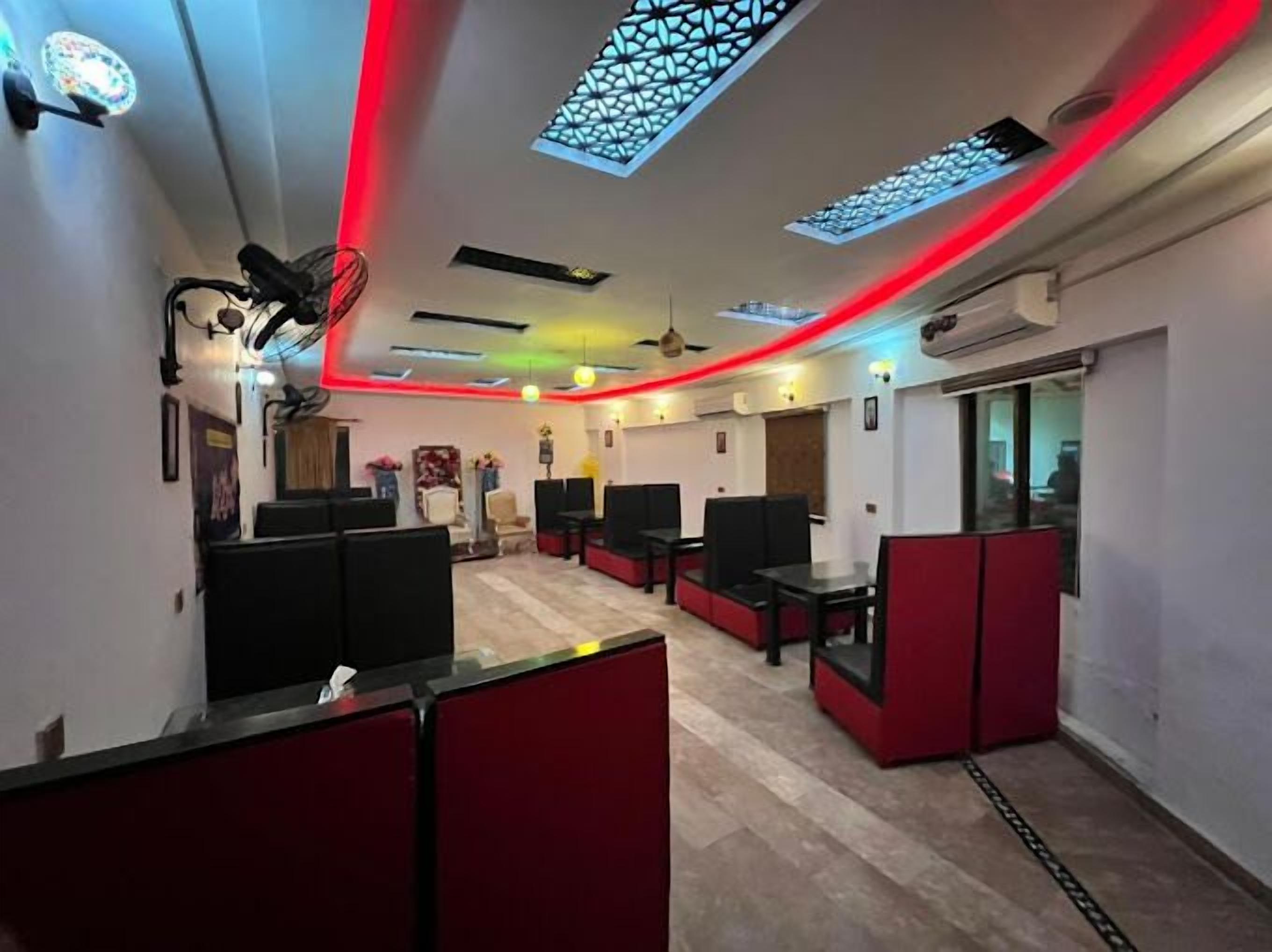 A modern interior with seating areas, a reception desk, and a patterned ceiling.