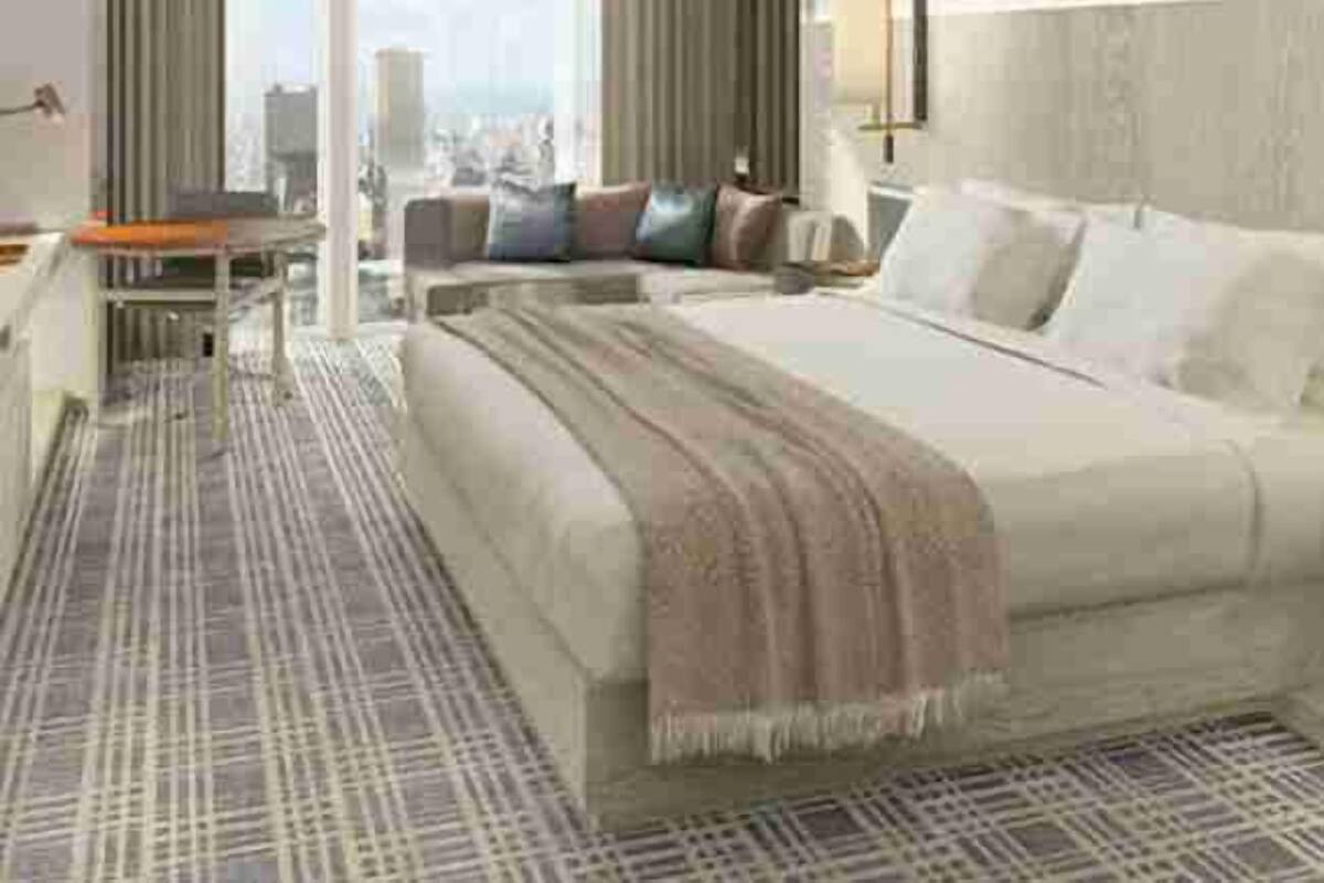A hotel room with a large bed, a desk, and a view of the city.