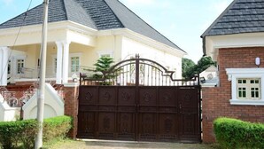 Une maison à deux étages, dotée d’une entrée fermée par un portail, d’un porche abrité et d’une façade en briques.