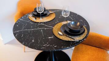 Una mesa redonda con dos platos negros, cada uno con un tapete tejido debajo.