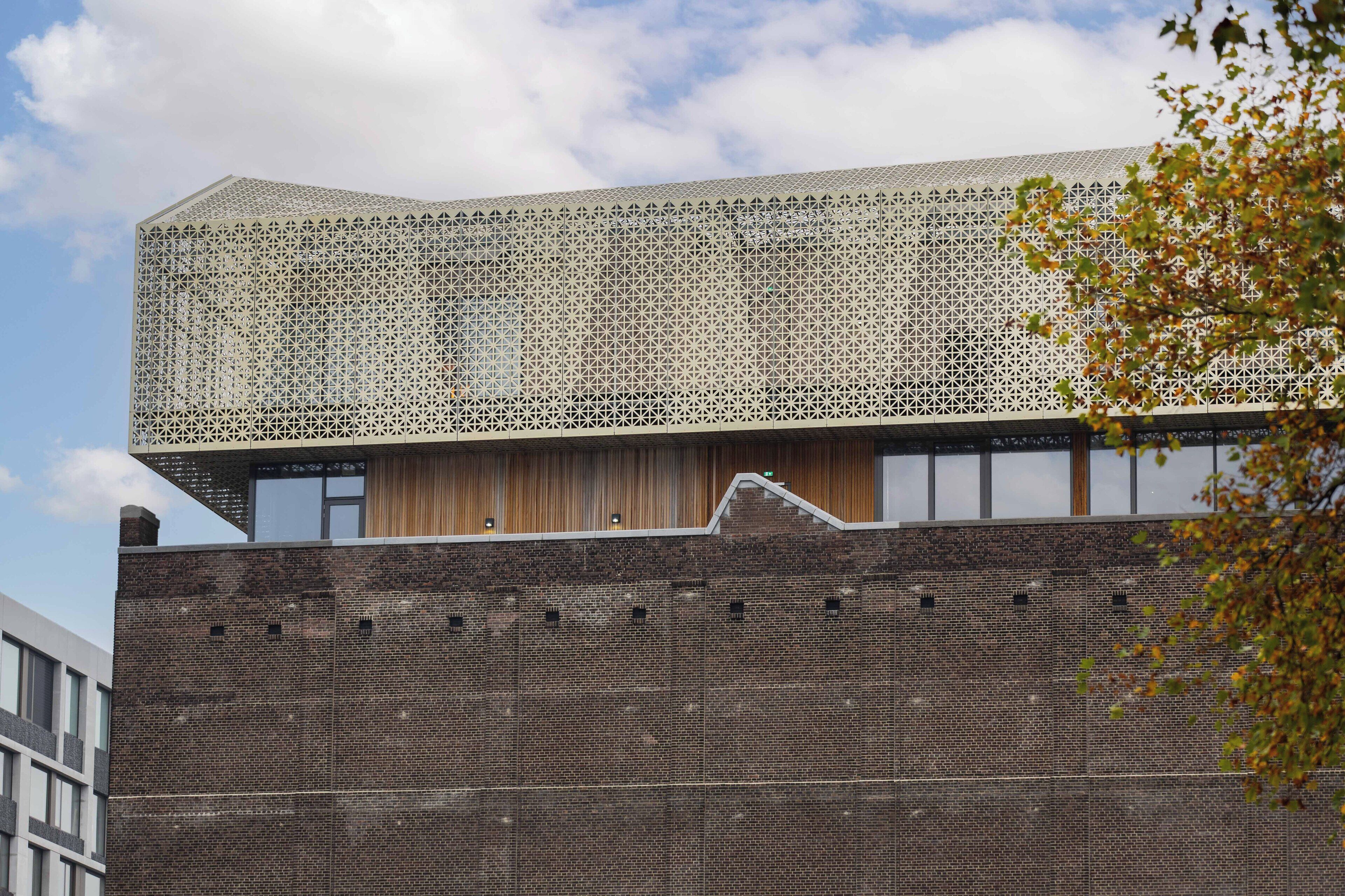 A modern building with a distinctive geometric facade and a brick base.