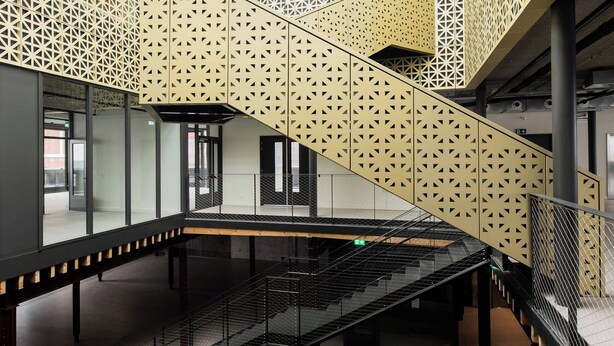 A modern interior with a central staircase, glass railings, and geometric patterned walls. - Alphabet Apartments Brede Hilledijk (Rotterdam)