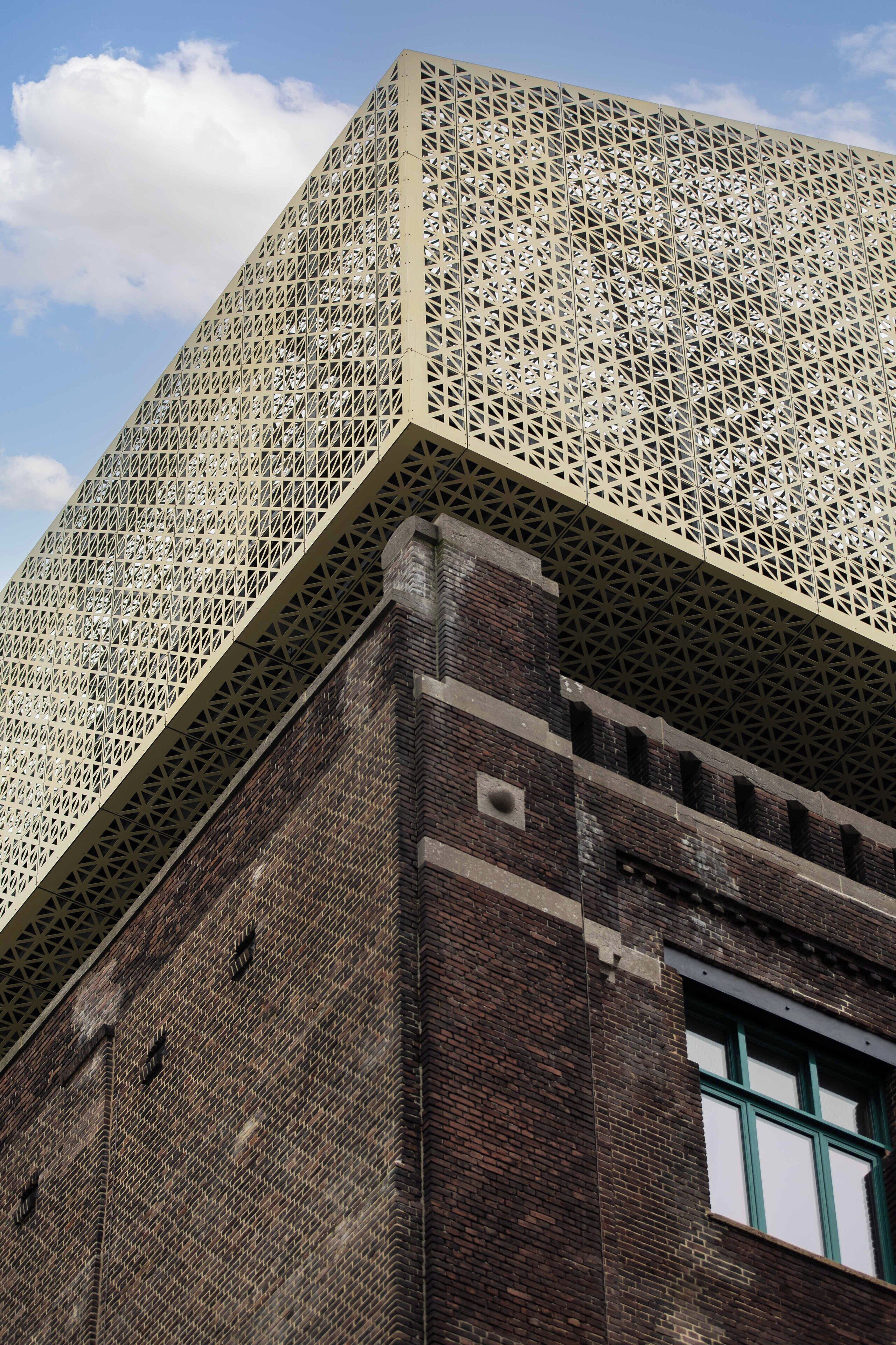 Een gebouw met een opvallende geometrische gevel en een zichtbaar raam.