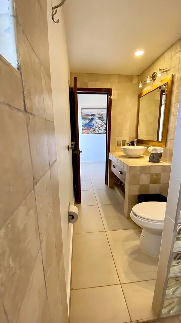Un baño con inodoro, lavamanos y espejo.