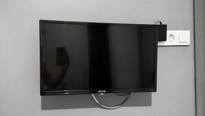A flat-screen TV mounted on a wall with a power outlet and cable management system. - Taksim Plaza Suite (Istanbul)