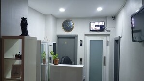 A reception area with a reception desk, a clock, a television, and a door marked '101'. - Taksim Plaza Suite (Istanbul)
