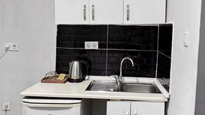 A compact kitchenette with a microwave, sink, and small refrigerator. - Taksim Plaza Suite (Istanbul)