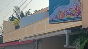 A two-story building with a large banner advertising 'Vibes Hotel'. There is a covered area with a motorcycle parked in front. - Vibes Hotel (Vagator)