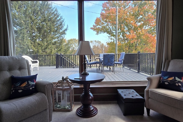 Large windows in TV room overlooking deck and backyard