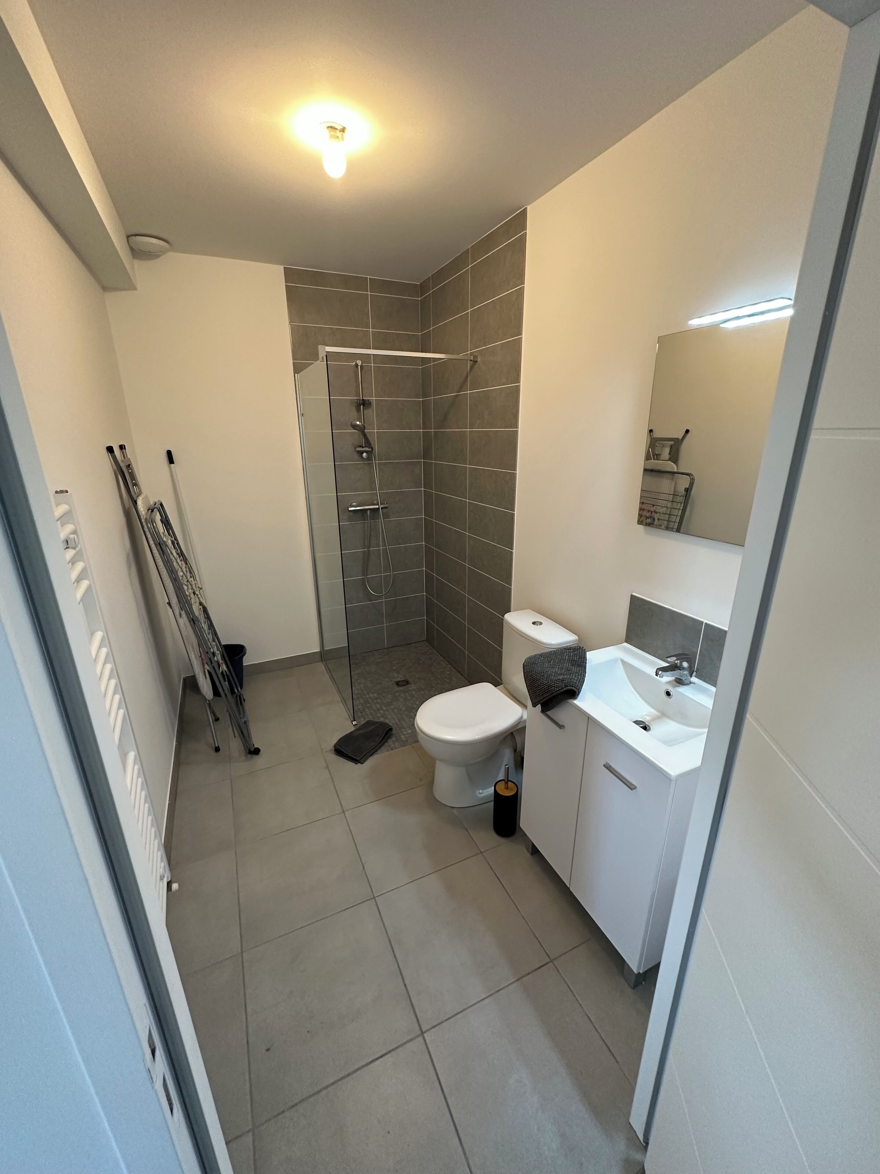 Un baño pequeño con ducha, inodoro y lavamanos.