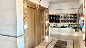 A hotel lobby with a reception desk, a fire extinguisher, and a wall-mounted wine rack. - Valleca Tren Sierra Guadalupe 1 (1 bedroom apartment) (Madrid)
