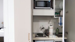 Une cuisine compacte équipée d’un four à micro-ondes, d’un grille-pain et d’un réfrigérateur.