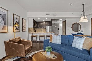 A modern living room with a blue sofa, a brown leather chair, and a small coffee table with a plant.