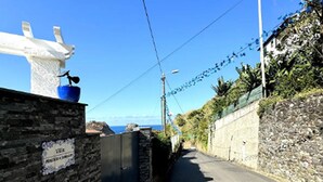 A narrow coastal road with stone walls and a clear view of the sea. - Studio in Porto da Cruz With Ocean Views (Machico)