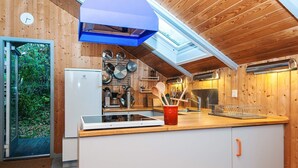 A modern kitchen with wooden walls, a built-in oven, and a skylight. - 5 Person Holiday Home in Knebel (Knebel)