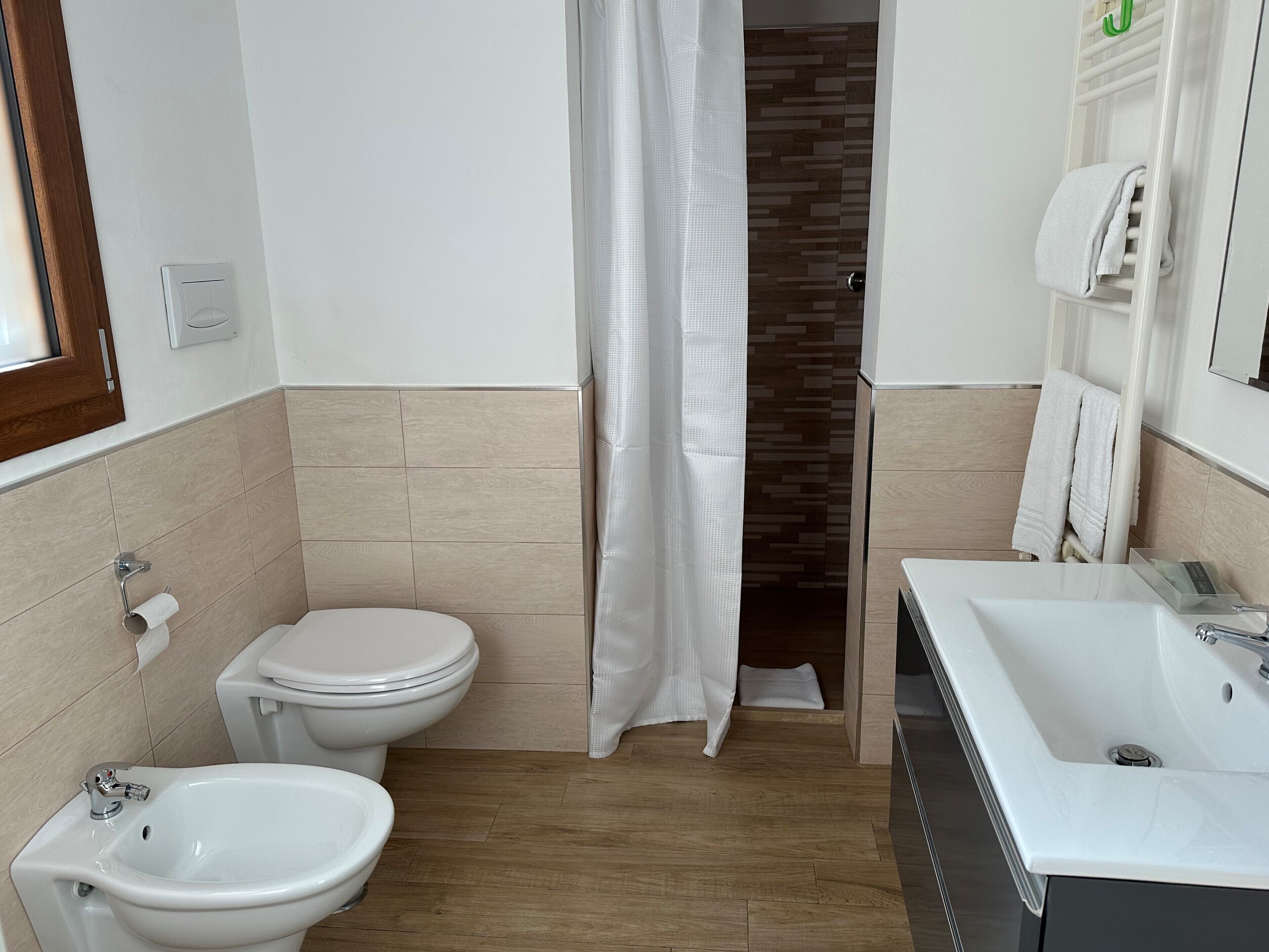 A bathroom with a toilet, bidet, and sink.