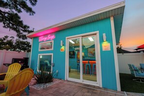 Un edificio con un letrero de neón que dice 'Flamingo Lounge' y una entrada con puerta de vidrio.