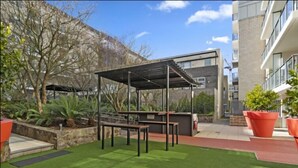 Zona exterior amb terrassa, una pèrgola, bancs i plantes en testos.