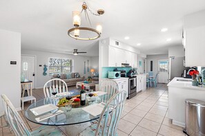 A modern kitchen with white cabinets, a blue microwave, and a stainless steel sink.