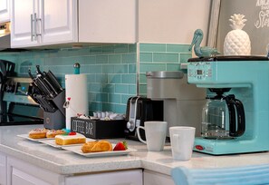 Une cuisine équipée d’une machine à café, d’une cafetière et d’un espace dédié à la préparation du café.