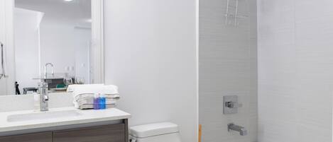 Une salle de bain moderne équipée de toilettes, d’un lavabo et d’une baignoire.