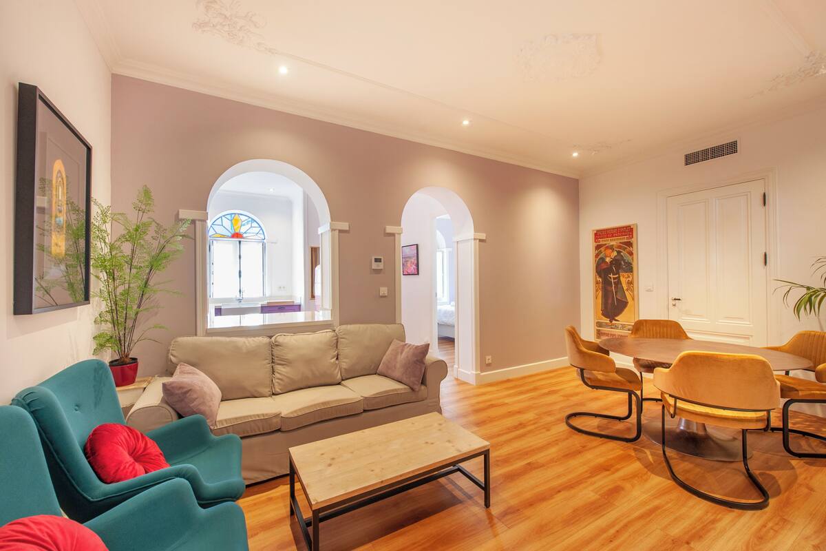 Un salon moderne comprenant un canapé, des fauteuils, une table basse et un coin repas avec une table et des chaises.