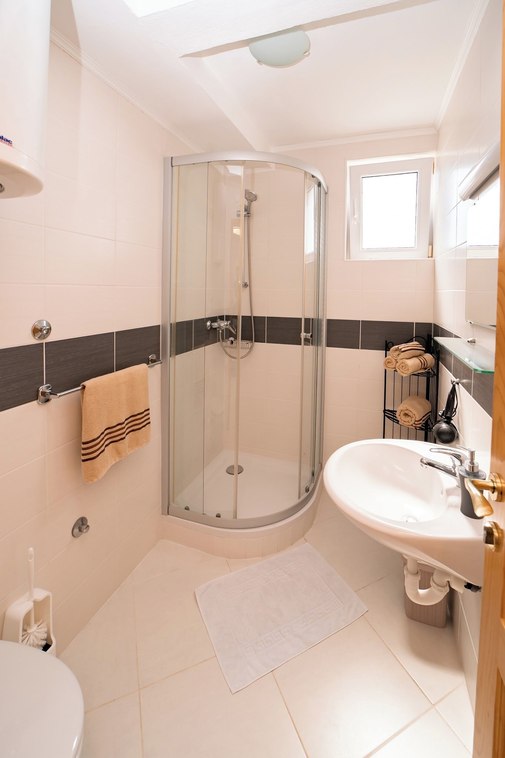 A modern bathroom with a glass shower enclosure, a white sink, and a toilet.