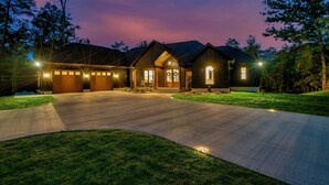 A modern house with a driveway, garage, and landscaped lawn.