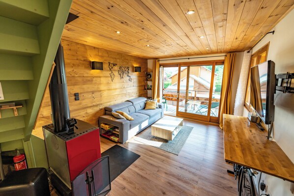 A modern living room with a wooden ceiling, a sofa, a coffee table, and a fireplace.