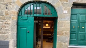 Un edificio de piedra con una entrada verde en arco y una puerta verde.